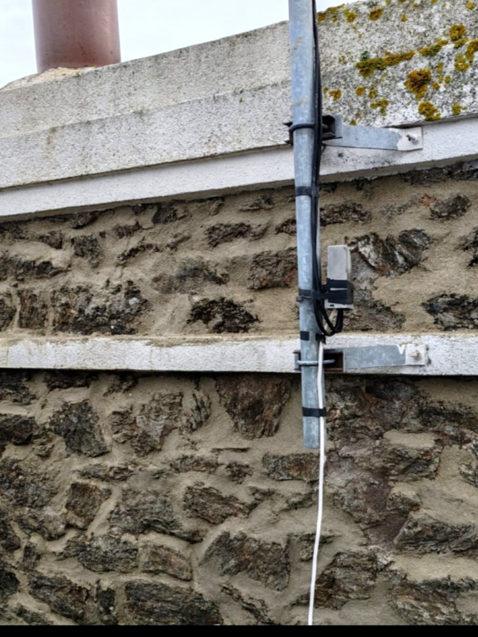 Grille de ventilation posée dans une façade en pierre après intervention