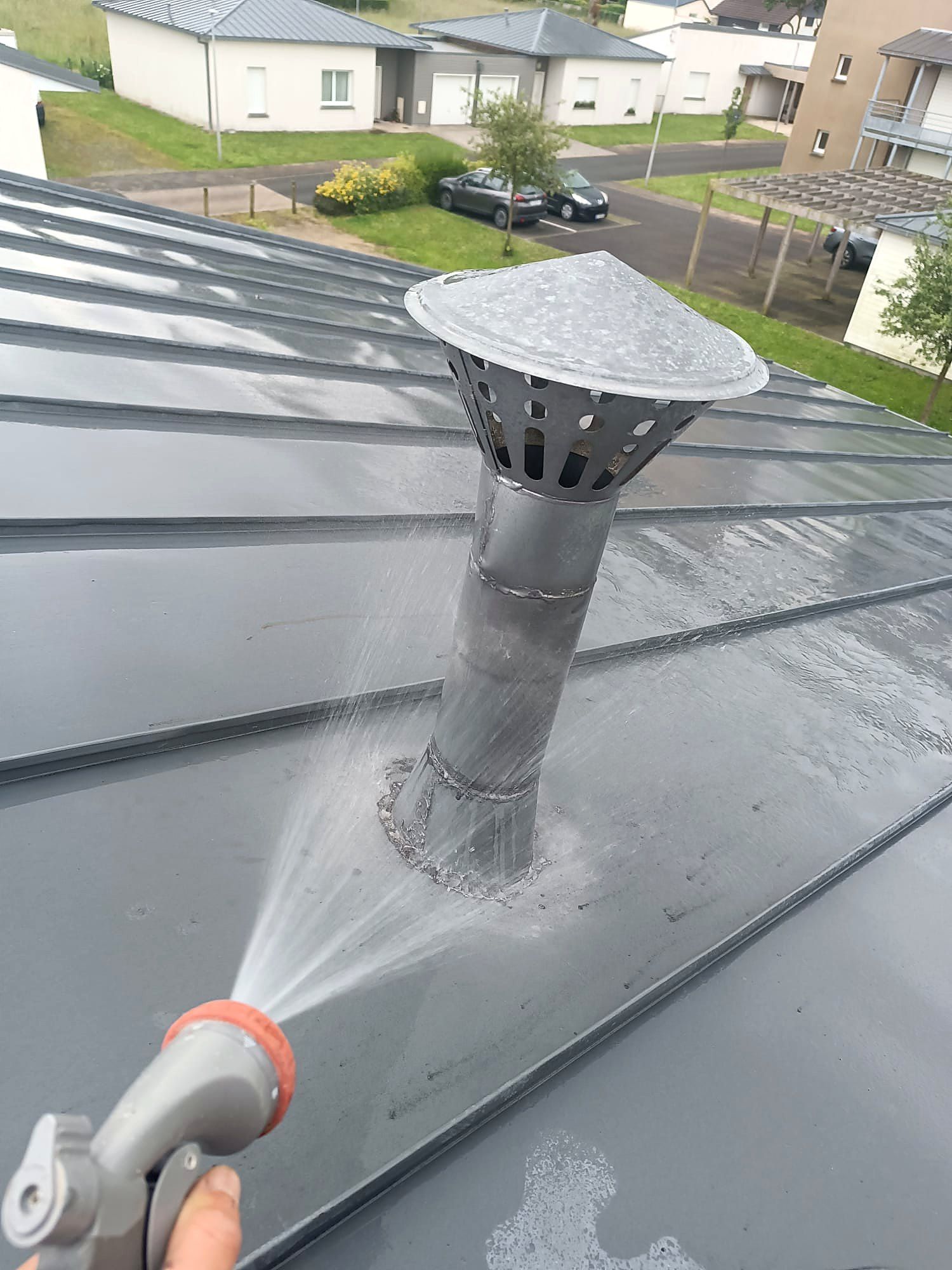 Test d'étanchéité au jet d'eau autour d'une sortie de toit en zinc